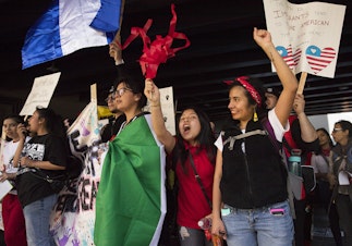 caption: Suri Emigdio, 11, second from right, and Rocio Carranza, right, cheer during the annual March for Immigrant and Workers Rights on Tuesday, May 1, 2018, in Seattle. Tap or click on the first image to see more.  