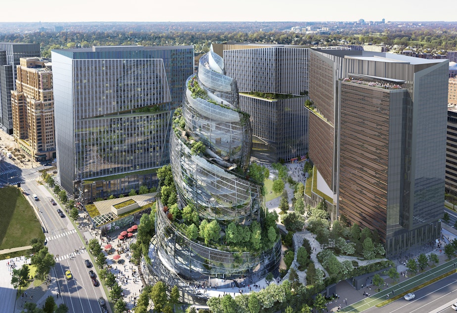 caption: This artist rendering provided by Amazon shows the next phase of the company's headquarters redevelopment to be built in Arlington, Va. Amazon is pausing construction of its second headquarters there following the biggest round of layoffs in the company's history and the shifting landscape of remote work.