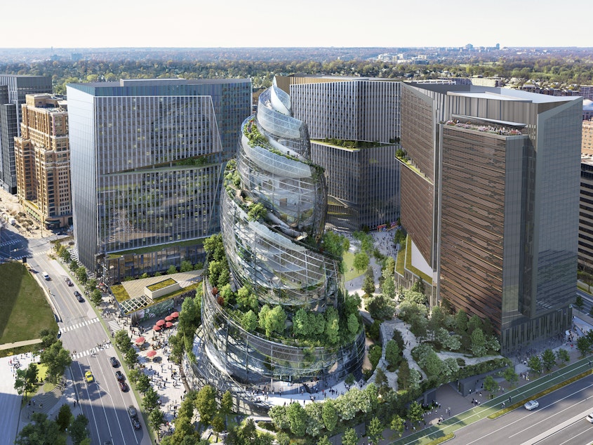 caption: This artist rendering provided by Amazon shows the next phase of the company's headquarters redevelopment to be built in Arlington, Va. Amazon is pausing construction of its second headquarters there following the biggest round of layoffs in the company's history and the shifting landscape of remote work.