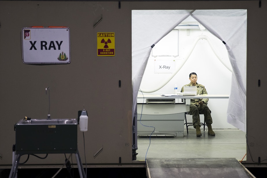 caption: Staff Sgt. Jordan Lambert sits inside the X-Ray area of the military field hospital inside CenturyLink Field Event Center on Sunday, April 5, 2020, in Seattle. The 250-bed hospital for non COVID-19 patients was deployed by U.S. Army soldiers from the 627th Army Hospital from Fort Carson, Colorado, as well as soldiers from Joint Base Lewis-McChord.