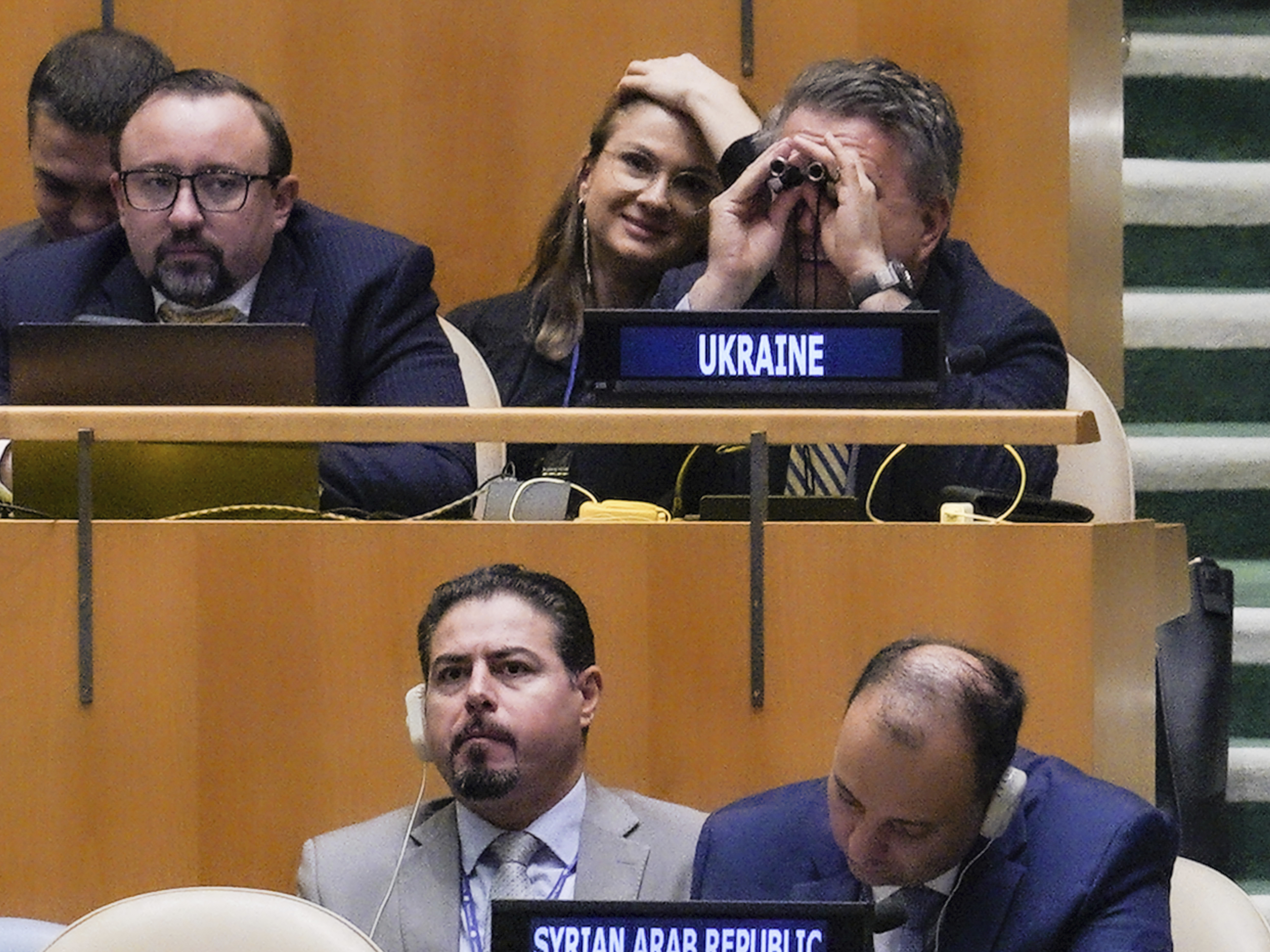 caption: U.N. Ambassador from Ukraine Sergiy Kyslytsya uses binoculars in the U.N. General Assembly before a vote condemning Russia's move to illegally annex parts of Ukraine.