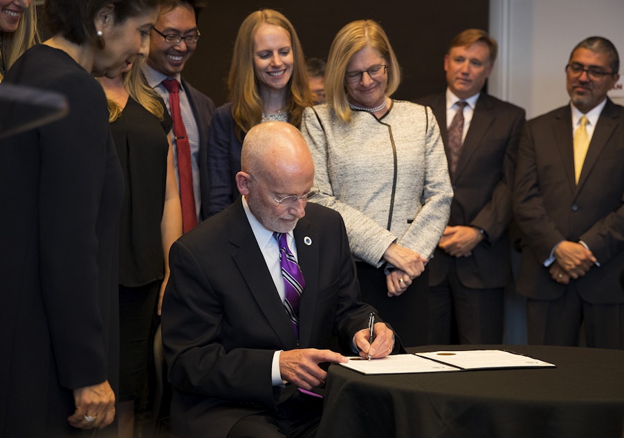 caption: FILE: Then-Councilmember Tim Burgess signs an official document after taking the oath of office and becoming the mayor of Seattle on Monday, September 18, 2017, at City Hall in Seattle.