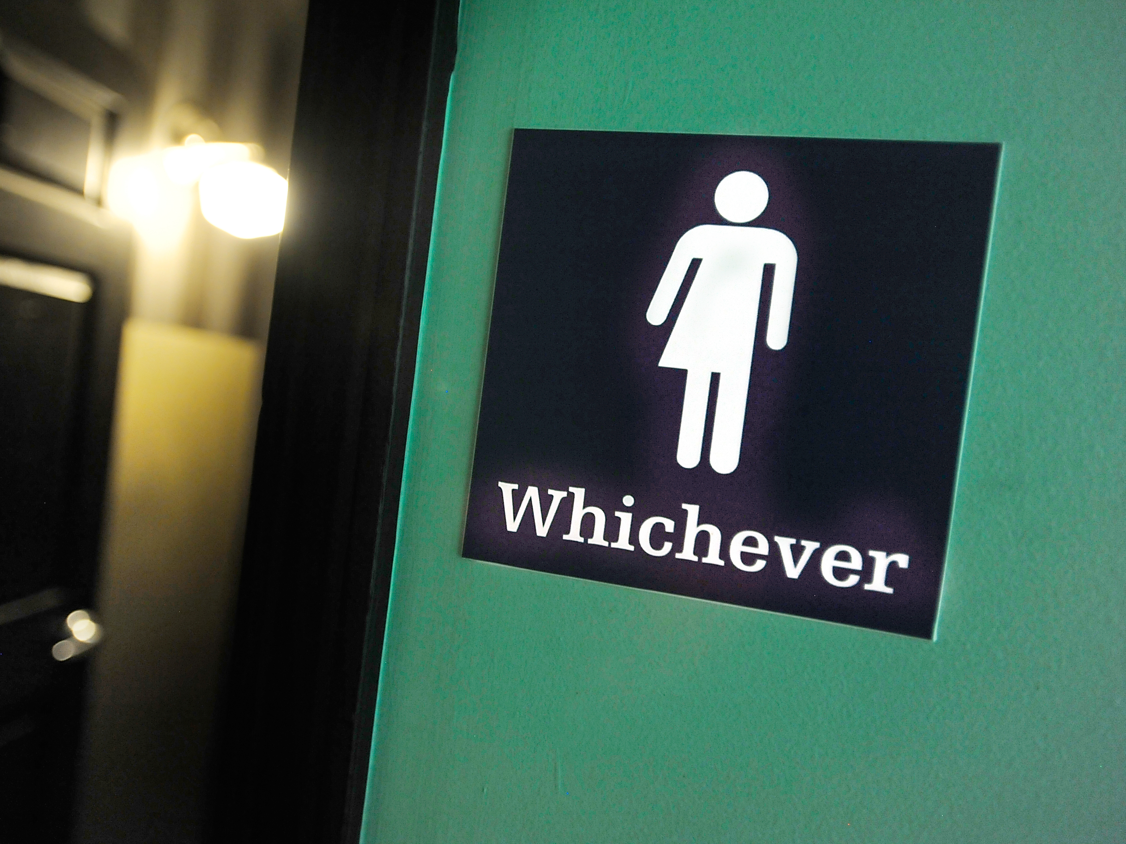 caption: A gender-neutral sign is posted outside a bathrooms at a restaurant in Durham, N.C. Many North Carolina businesses put gender-neutral signs on toilets after the "bathroom bill" was passed.