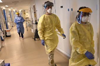 caption: Coronavirus deaths in the U.K. have passed those in Italy. Workers in the intensive care unit at the Royal Papworth Hospital in Cambridge are shown gearing up to care for COVID-19 patients.
