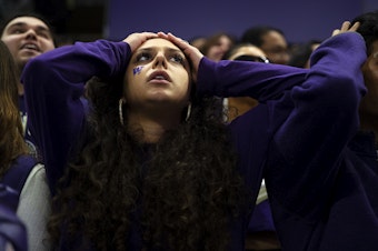 caption: University of Washington senior Aziza Zeighami, reacts to a play during the first quarter of the college playoff National Championship game against Michigan, on Monday, January 8, 2024, at Alaska Airlines Arena in Seattle.  