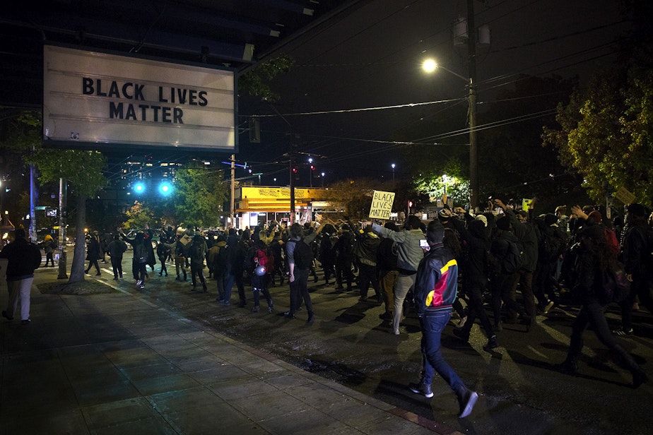 caption: Demonstrators march from Cal Anderson Park to Westlake Park on Monday, October 26, 2020, during the 150th day of protests for racial justice in Seattle.