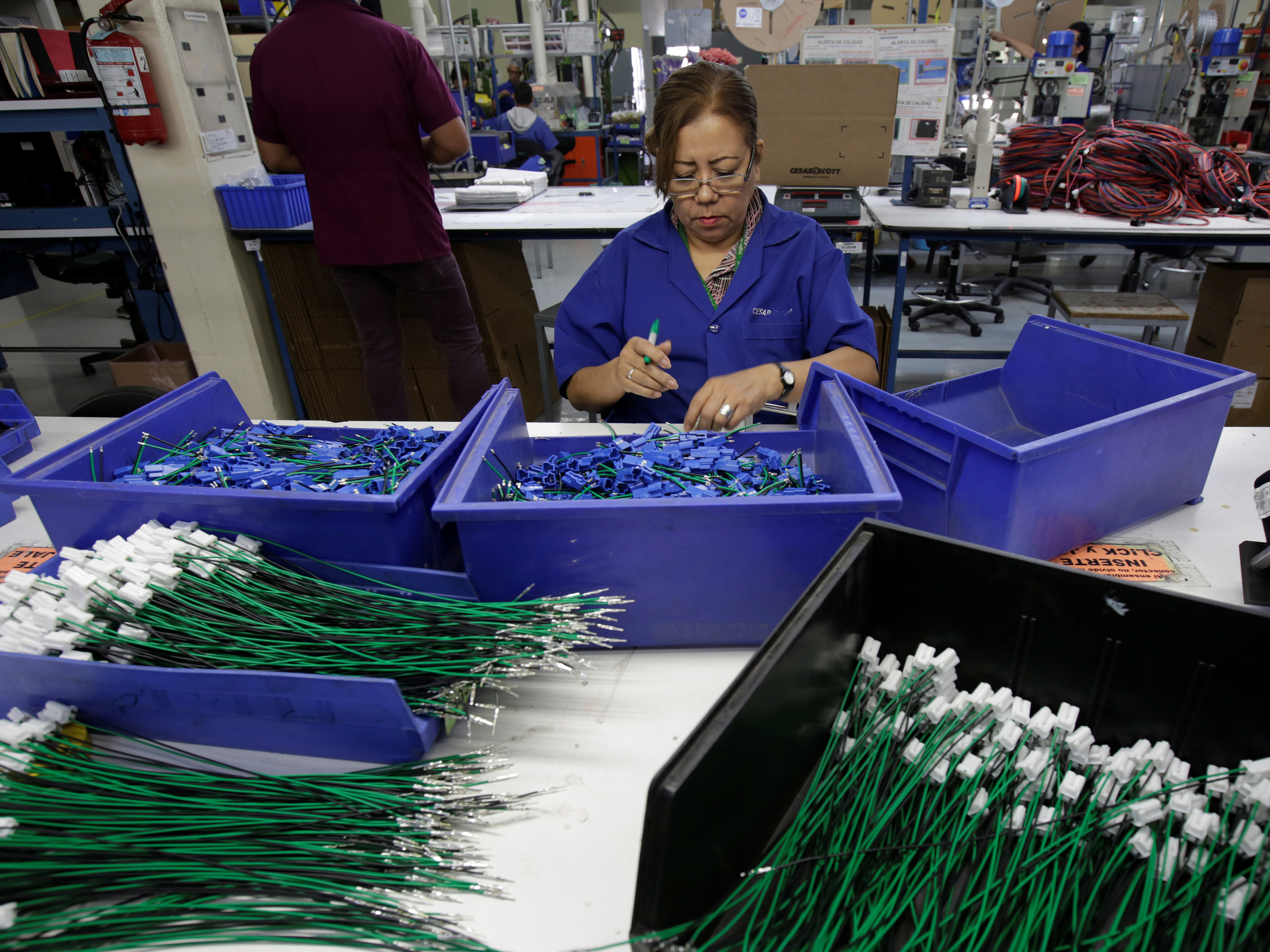 caption: An employee works at a wire harness and cable assembly manufacturing company that exports to the U.S. in Ciudad Juárez, Mexico, on April 27, 2017. The auto industry says threatened tariffs would increase the cost of imported vehicles and play havoc with supply chains.
