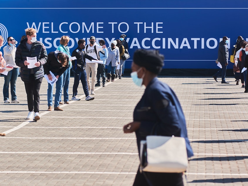 caption: Residents wait to register at a mass vaccination site in Johannesburg on July 8.