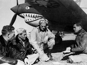 caption: Pilots from the American Volunteer Group sit in front of a P-40 airplane in Kunming, China, on March 27, 1942. The group was notable for its unusual mission: Its members were mercenaries hired by China to fight against Japan.