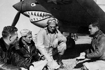 caption: Pilots from the American Volunteer Group sit in front of a P-40 airplane in Kunming, China, on March 27, 1942. The group was notable for its unusual mission: Its members were mercenaries hired by China to fight against Japan.