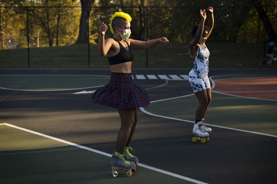 caption: Theo, left, and Tralonda Walker, right, skate during a decades themed skate meet up with Seattle Skates on Tuesday, October 6, 2020, at the White Center Bicycle Playground in Seattle. 