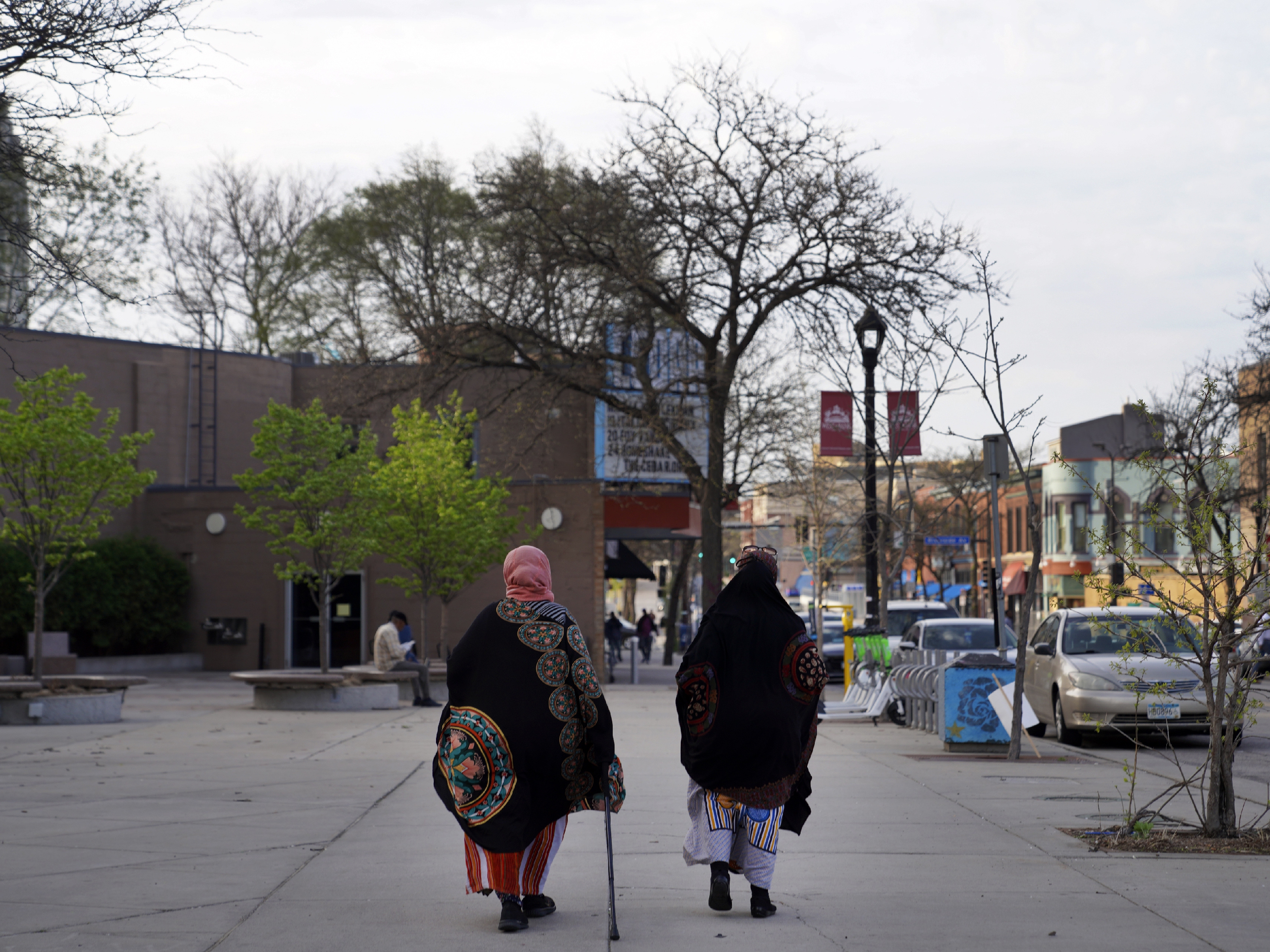 caption: Women walk down a street in the predominantly Somali neighborhood of Cedar-Riverside in Minneapolis in 2022. The Twin Cities is a hub for Somalis in the U.S.