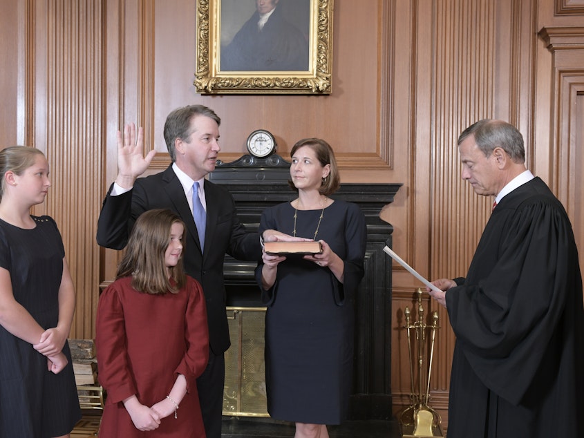 caption: Chief Justice John Roberts administers the constitutional oath to Judge Brett M. Kavanaugh as his wife, Ashley Kavanaugh, holds the Bible. They're accompanied by their daughters, Margaret and Liza.