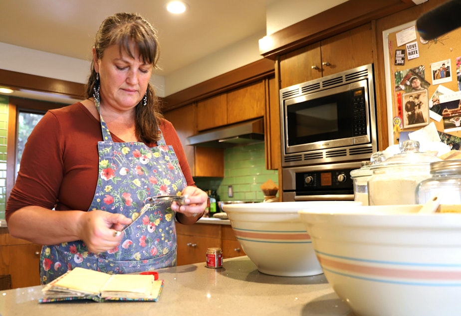 caption: Lanne Stauffer preparing ingredients for pumpkin cranberry muffins that will go into her little free bakery. 