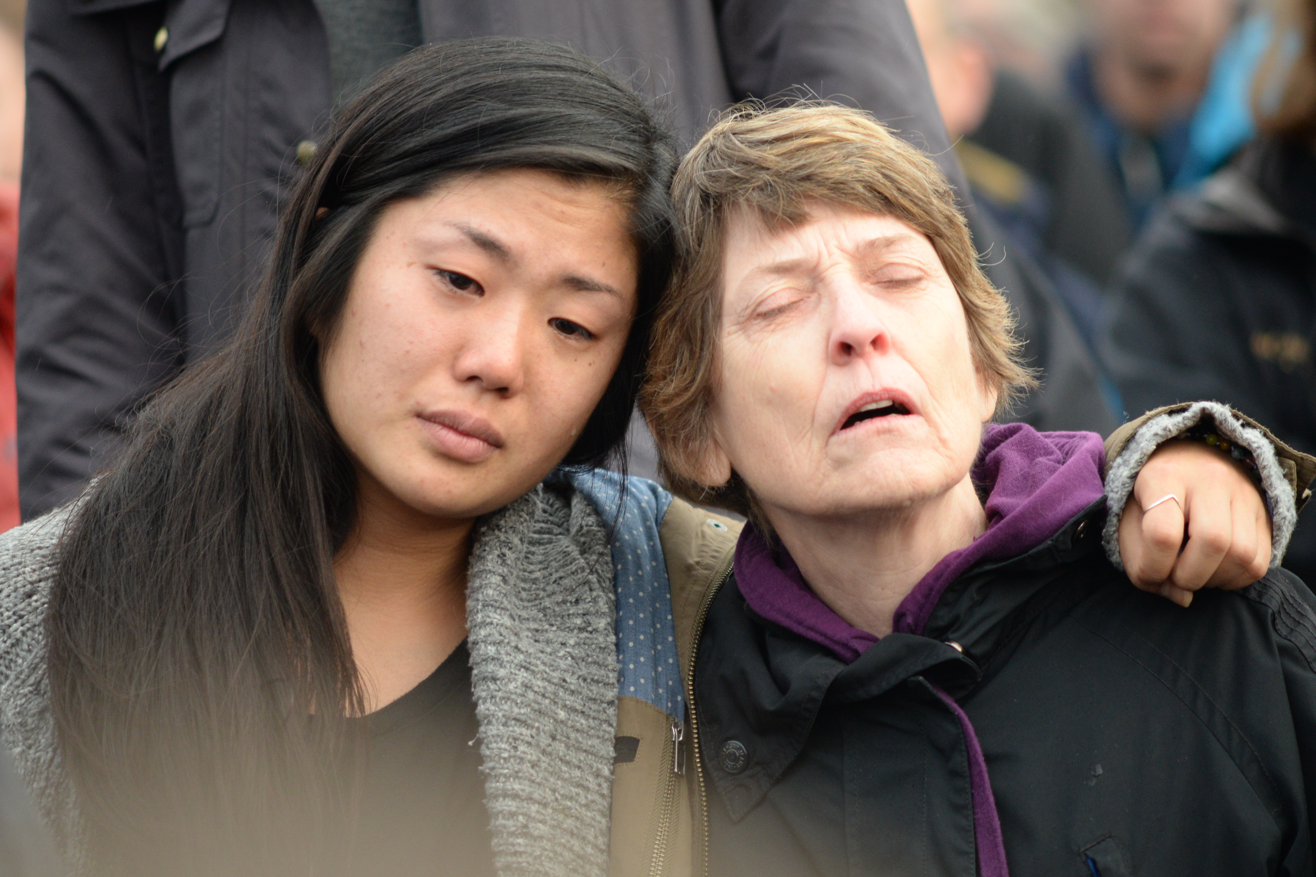 caption: Hannah Atlas hugs her mom, Judith Gille, as the crowd sings the late Leonard Cohen's "Hallelujah" during a vigil Sunday at Seattle's Cal Anderson Park. 