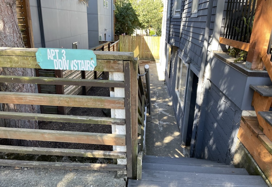 caption: A sign leads visitors to a basement apartment in an older home in Seattle's Rainier Valley