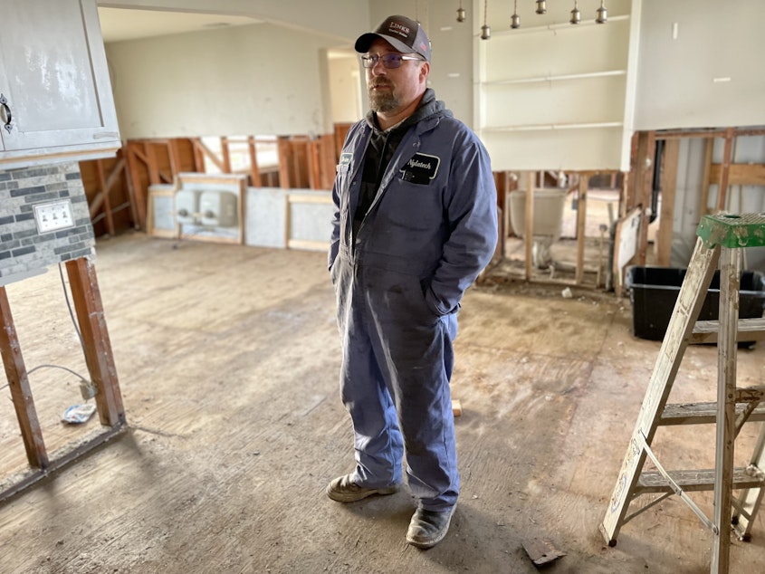 caption: Dexter Cunningham in his damaged Everson home. He's had to cut out all finish materials from 4 feet down, because the floodwaters were 3 feet inside his home.