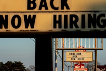 caption: Signs with the message 'Now Hiring' are displayed in front of restaurants in Rehoboth Beach, Delaware, on March 19.