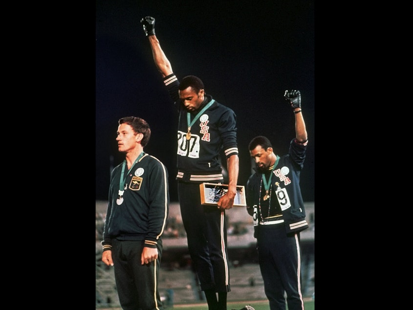 caption: In this Oct. 16, 1968, photo, U.S. athletes Tommie Smith, center, and John Carlos raise their gloved fists after Smith received the gold and Carlos the bronze for the 200 meter run at the Summer Olympic Games in Mexico City.