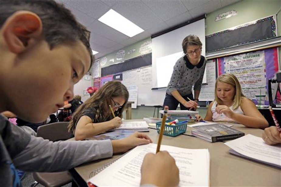 caption: Teacher Joy Burke holds a new position at John Hay Elementary, Seattle, which allows her to give extra attention to students. Education advocates are pushing a state measure limiting class sizes; opponents worry it could make the budget situation worse.