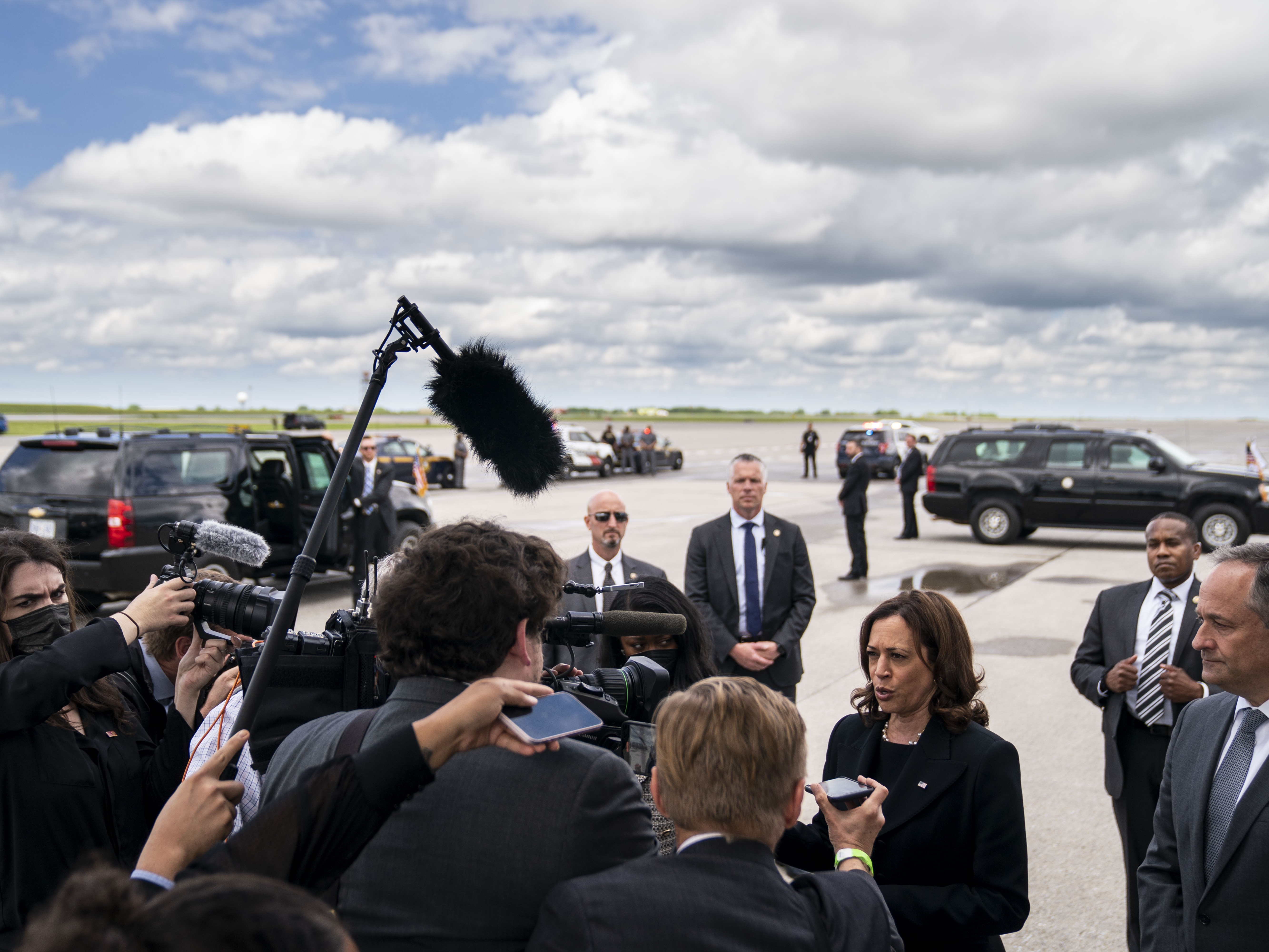 caption: Kamala Harris, shown here as vice president in 2022, speaks to the traveling press pool as second gentleman Doug Emhoff looks on, under the wing of Air Force 2 at Buffalo-Niagra International Airport.