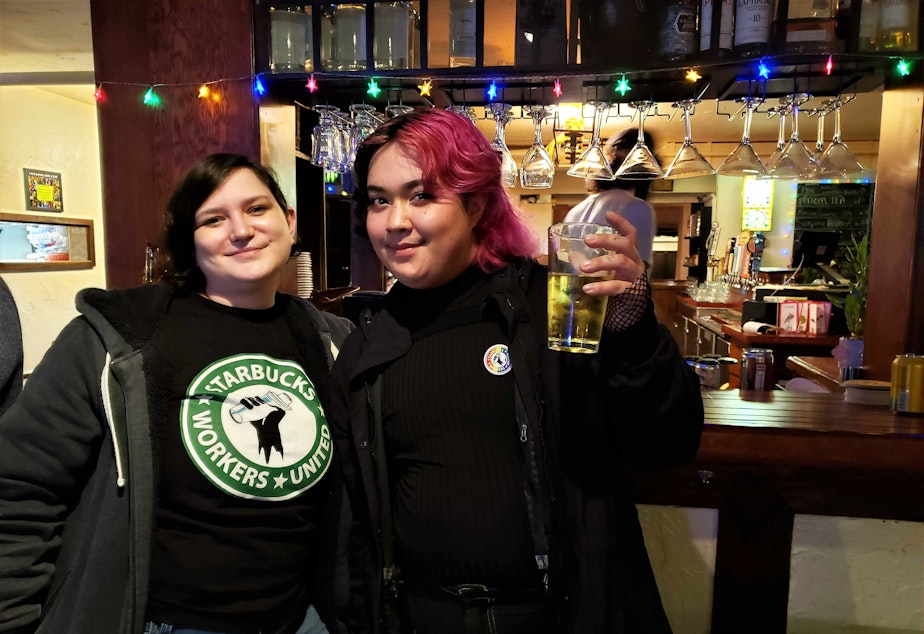 caption: Starbucks shift manager Sarah Pappin and barista Phoenix Vinup at a union solidarity happy hour in March, 2022