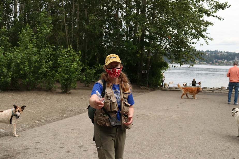 caption: My mom offers me hand sanitizer after I touch the gate at the Magnuson Park dog park. She is frustrated because I take pictures instead.