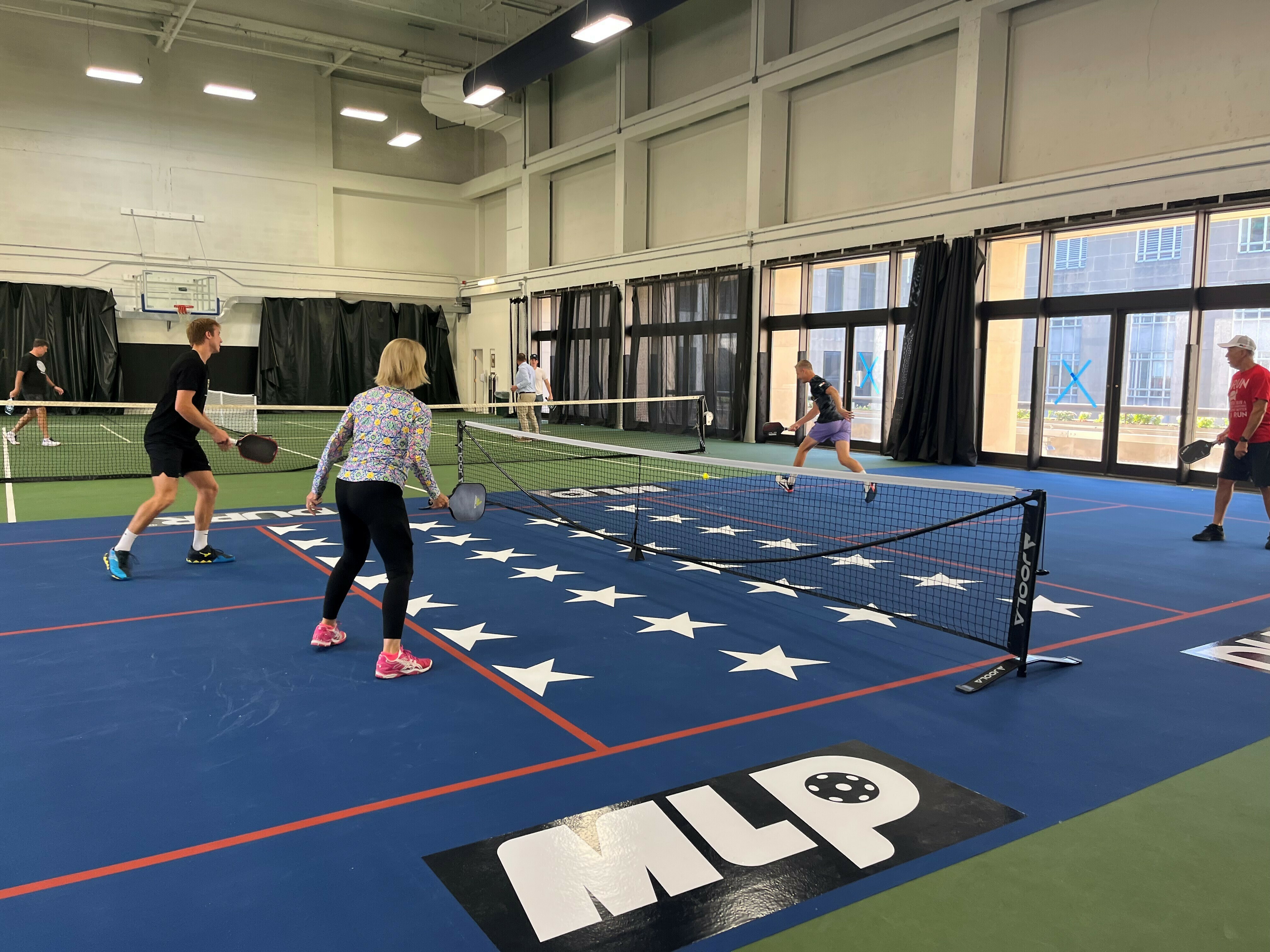 caption: Sens. Shelley Moore Capito, R-W.Va., and Thom Tillis, R-N.C., face off in a game of pickleball in the Dirksen Senate Office Building, along with members of the D.C. professional team.