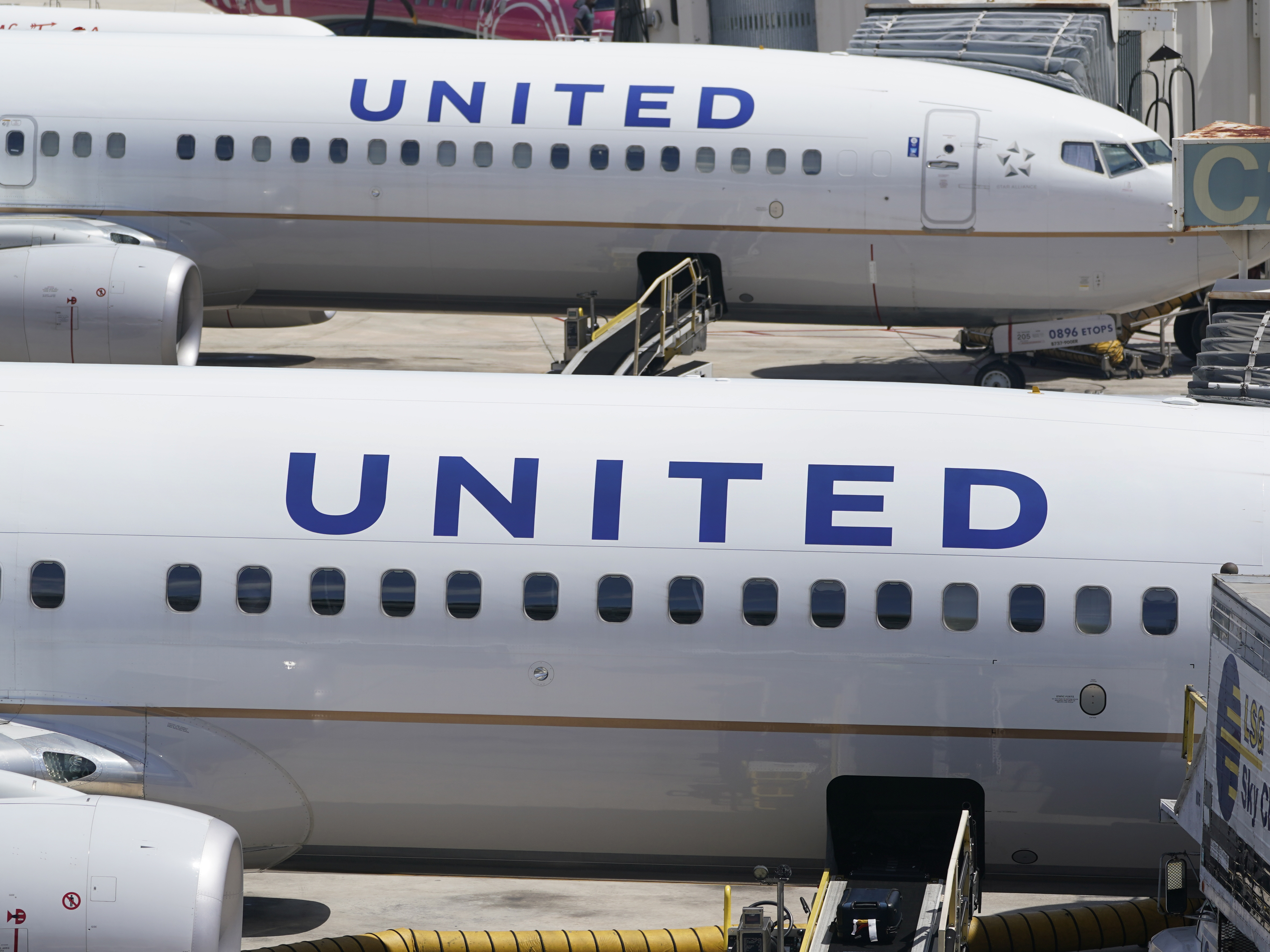 caption: Two United Airlines Boeing 737s are parked at the gate at the Fort Lauderdale-Hollywood International Airport in Fort Lauderdale, Fla., on July 7, 2022.
