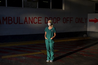 caption: Emergency medical medical officer Dr. Storm Bissict, 35, photographed outside the ER entrance of Netcare Christiaan Barnard Memorial Hospital, Cape Town, South Africa, on the morning of January 19. To escape the stresses of her job during a pandemic, she dives into the ocean.