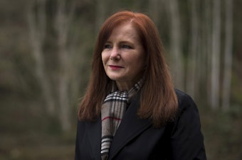 caption: Susan Krikac stands for a portrait outside of her home on Wednesday, February 17, 2021, in Seattle. After testing positive in July, she is still experiencing various symptoms of Covid-19 today, seven months later. "It was so isolating," Krikac said of the experience at the beginning. "You're just afraid every night that you're going to die in the middle of the night."