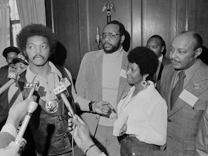 caption: This March 26, 1972 file photo shows the Rev. Jesse Jackson speaking to reporters at the Operation PUSH Soul Picnic in New York as Tom Todd, vice president of PUSH, from second left, Aretha Franklin and Louis Stokes.