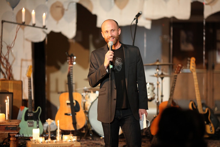 caption: Nathan Marion stands on stage at the Fremont Abbey during a community concert.