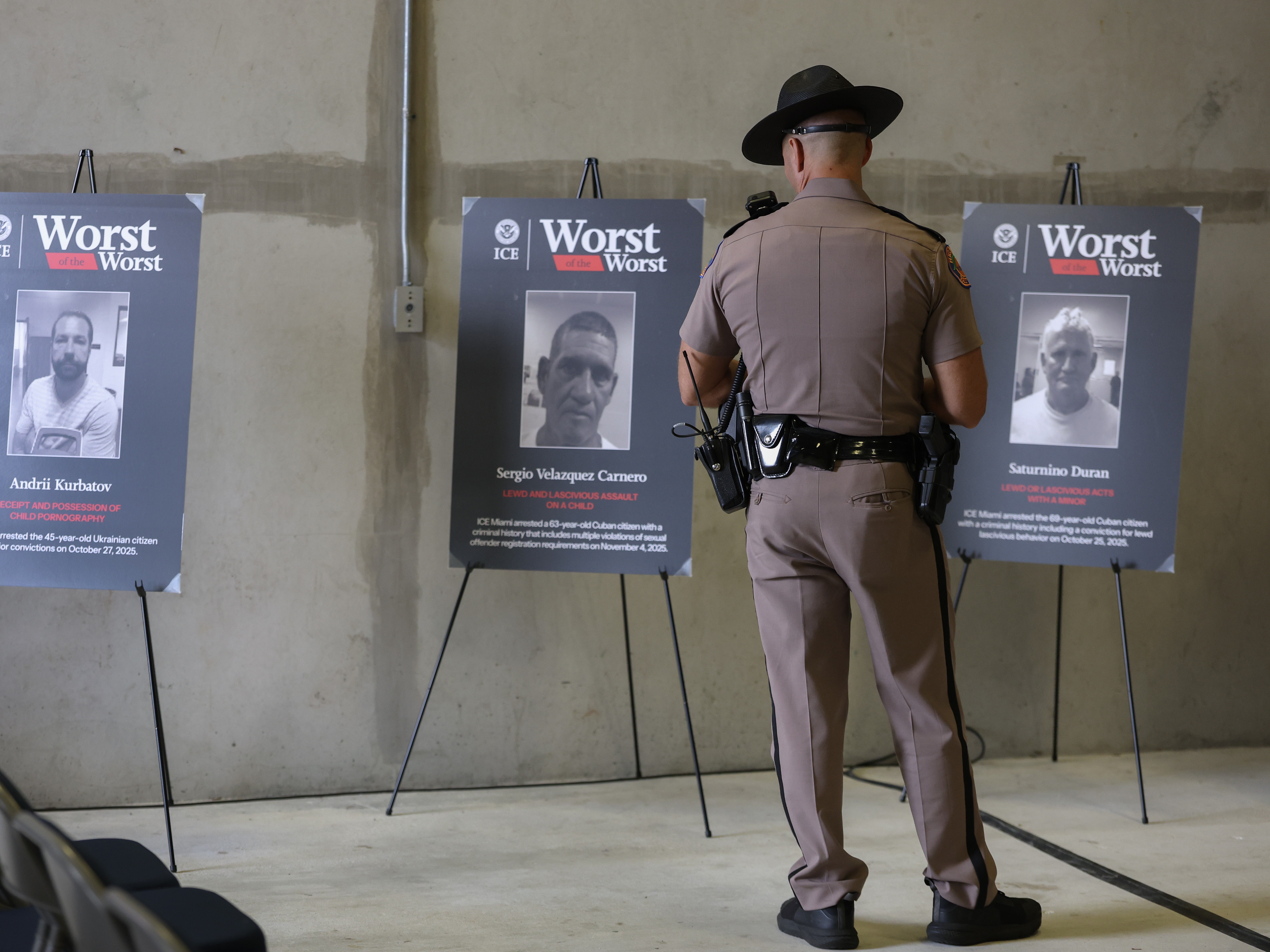 caption: A Florida Highway Patrol officer looks at pictures of undocumented immigrants accused of crimes before a press conference at the ICE Enforcement and Removal Operations building on November 13, 2025 in Miramar, Florida. Florida law enforcement agencies have among the highest ICE cooperation rates in the nation, with state troopers making a significant number of immigration arrests.