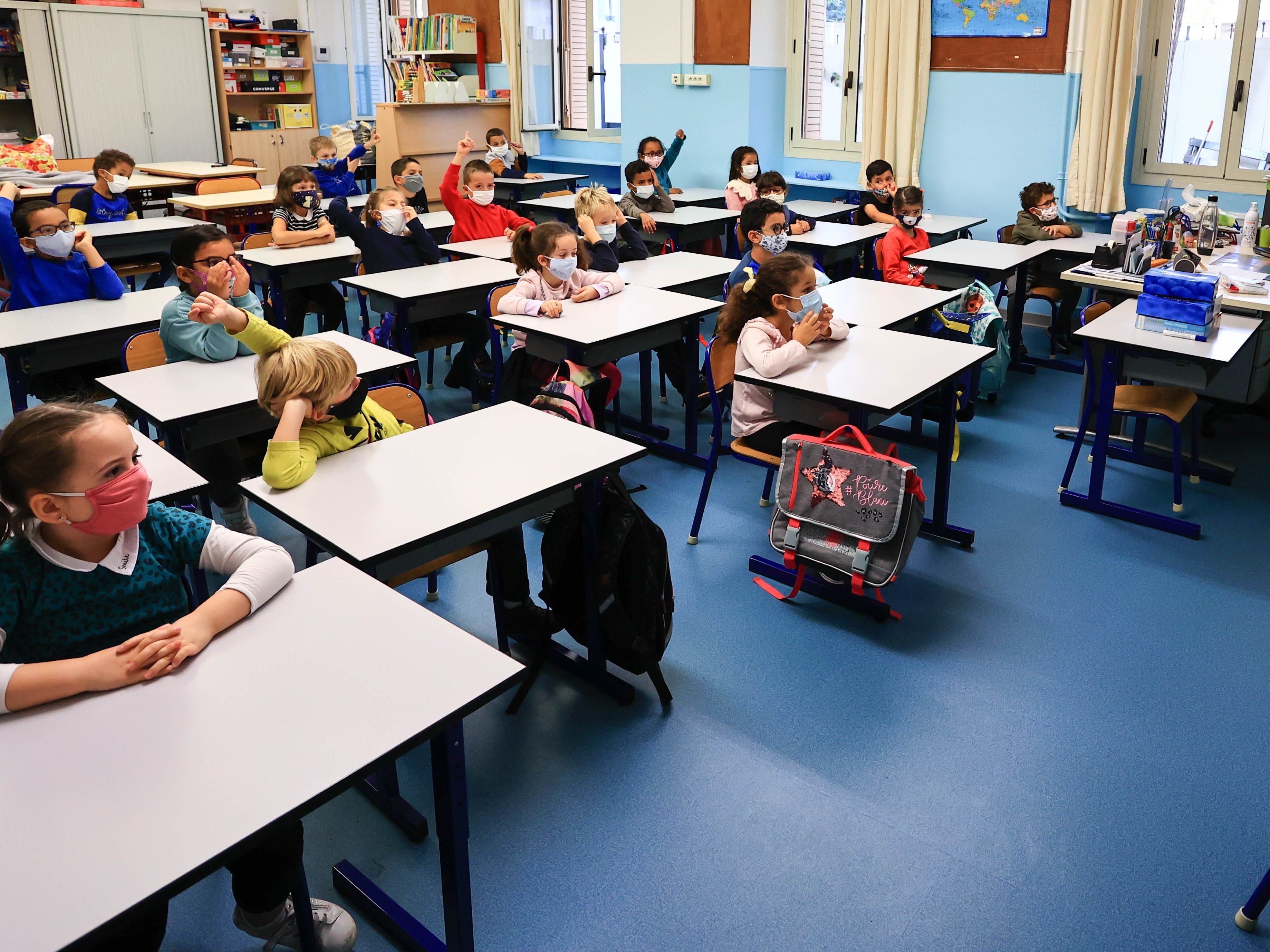 caption: Students attend class wearing face masks in Antibes, France, on Nov. 2. At the end of October, France returned to a partial national lockdown to stem a surge in coronavirus cases. Meanwhile, schools remain open.