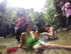 caption: Marta Amaro and Liset Barrios take a minute to rest after crossing a river in the Darien Gap, the untamed jungle that engulfs the Colombia-Panama border. Photographer Lisette Poole went with them to document their journey north.