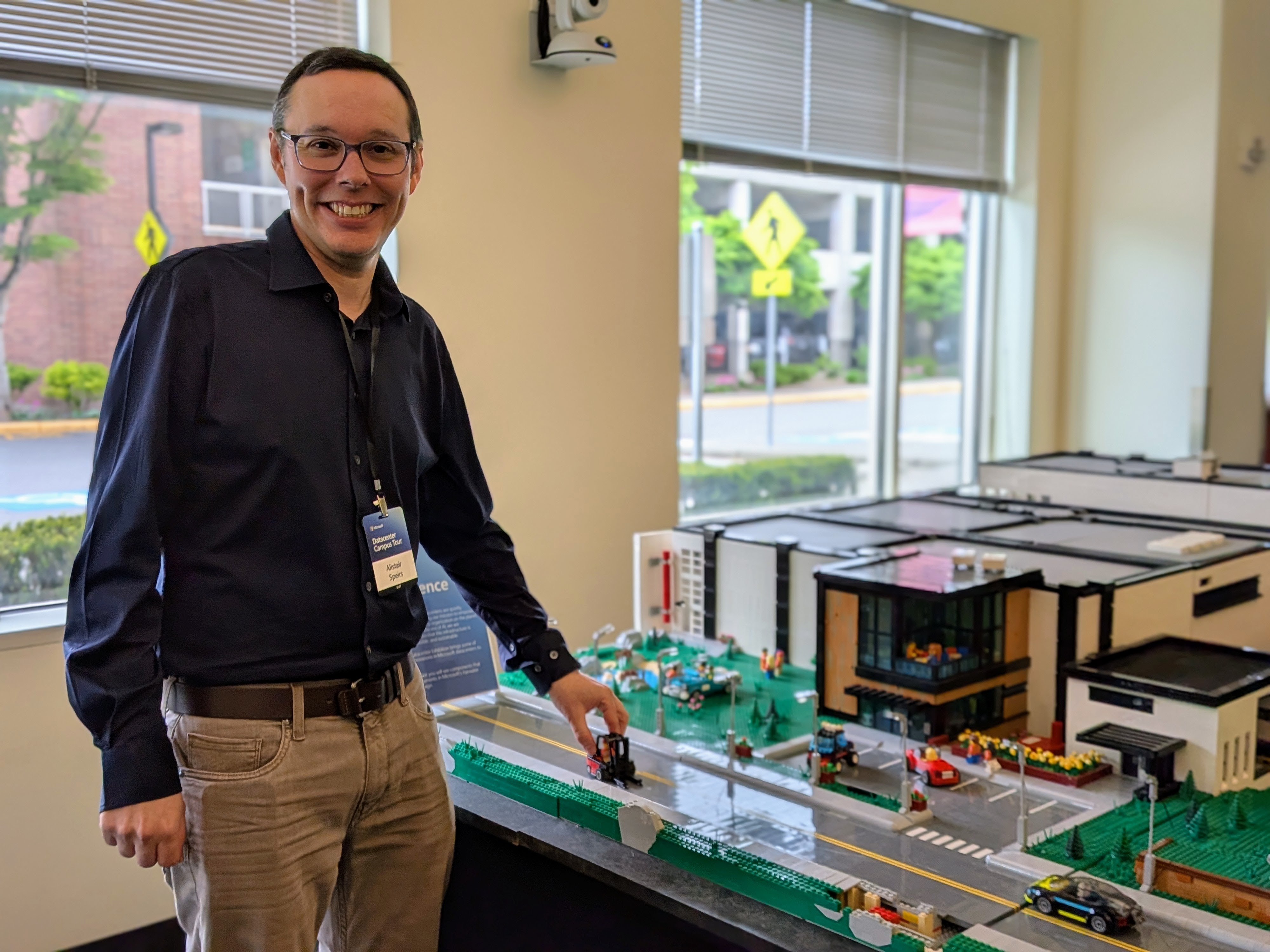 caption: Microsoft's general manager of Azure infrastructure, Alistair Speirs, poses with a Lego replica of a hyperscale data center.