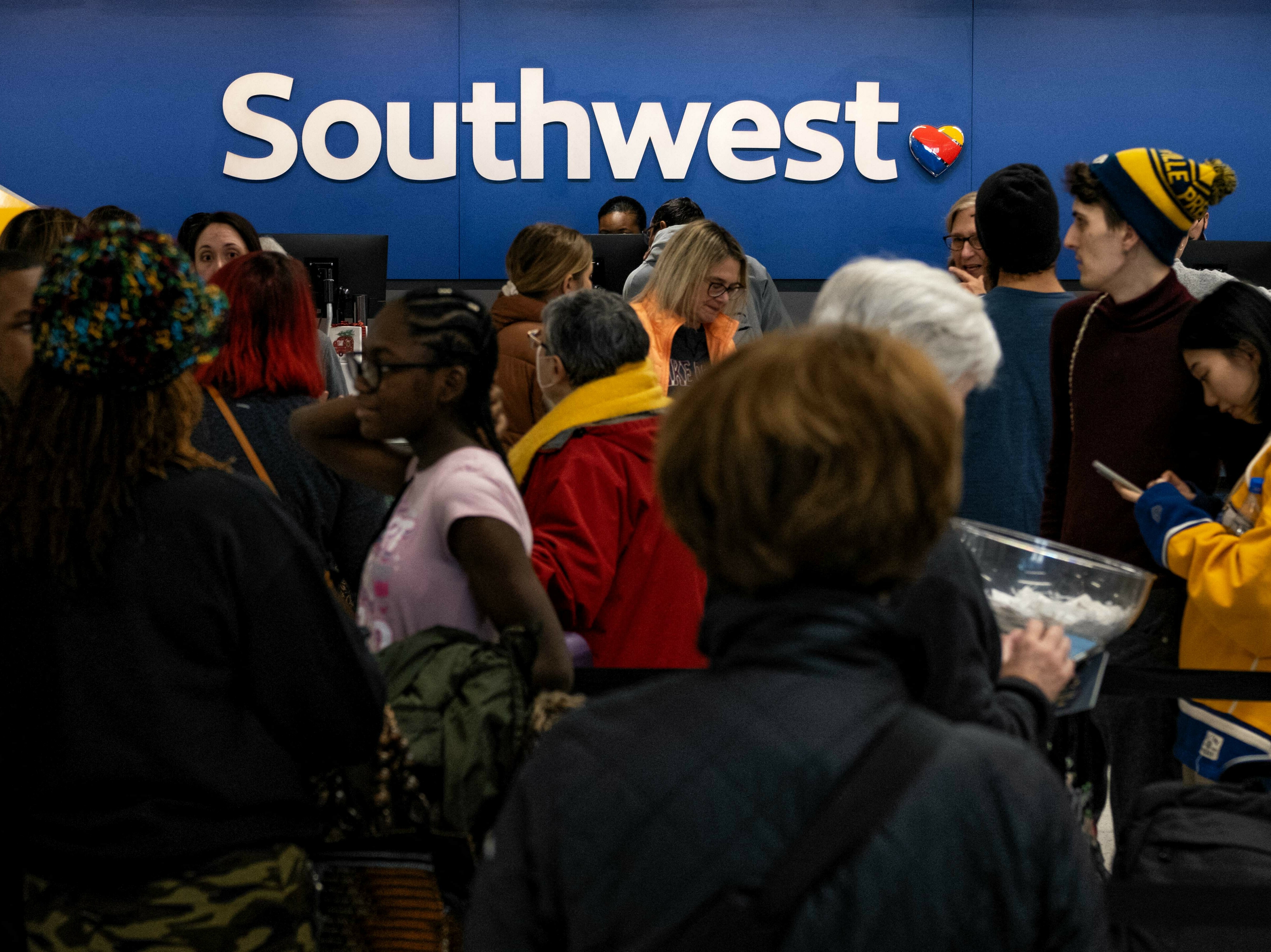 caption: Travelers wait in line at the Southwest Airlines ticketing counter at Nashville International Airport after the airline cancelled thousands of flights in Nashville, Tennessee, on December 27, 2022.