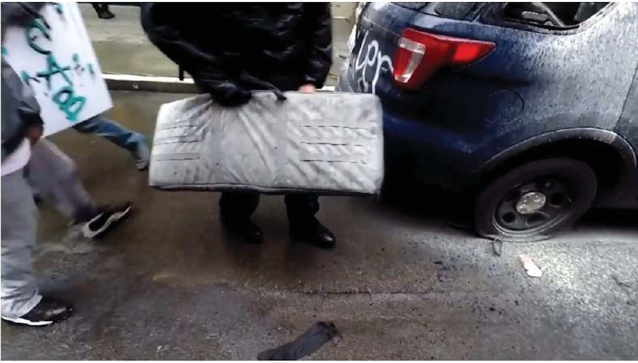 caption: Federal charging documents allege that this frame from a Youtube video depicts the theft of an SPD rifle in downtown Seattle on May 30, 2020. 