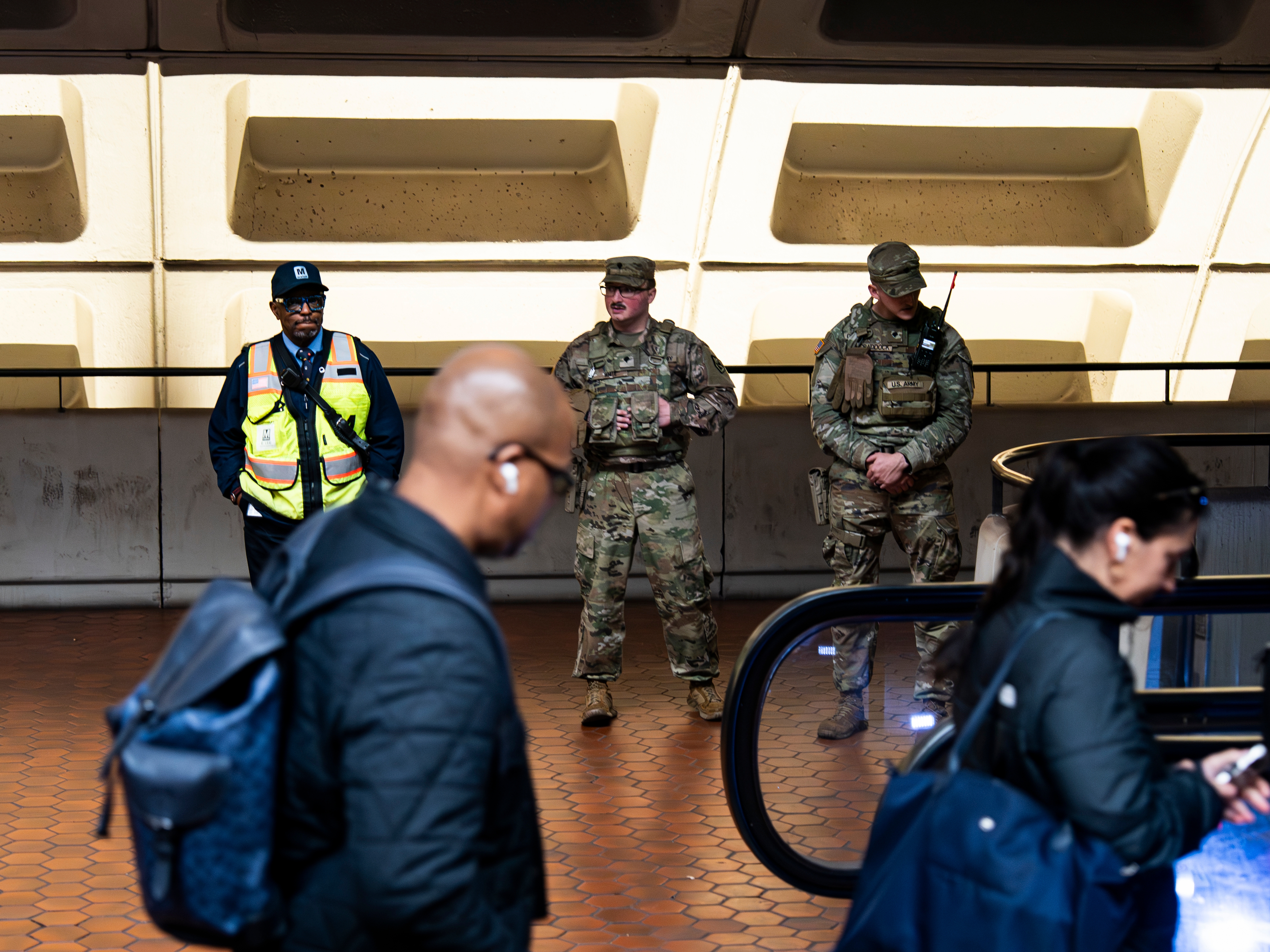 caption: Members of the National Guard stand by an escalator at the Farragut North Metro station in Washington, D.C. on Nov. 13.
