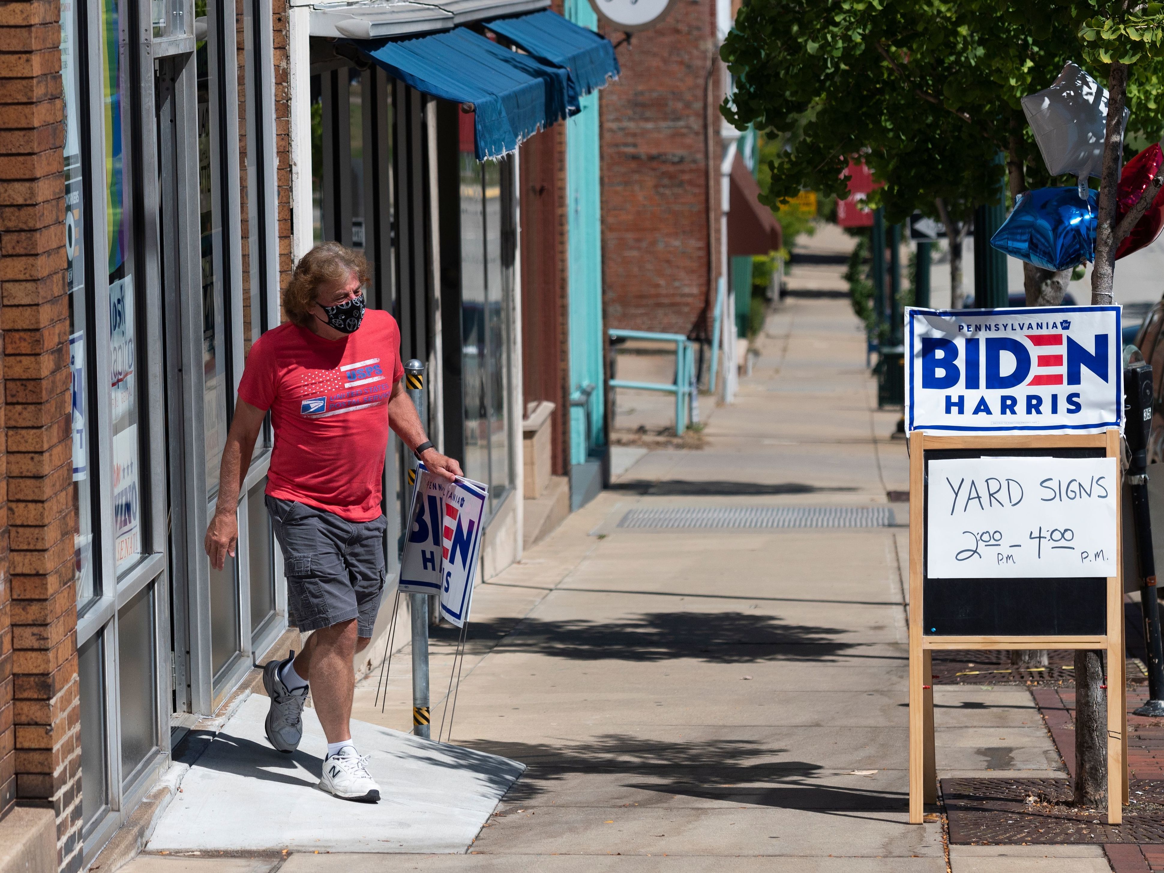 caption: A man walks out of the Washington County Democratic Party office last week, in the suburbs of Pittsburgh, after taking a Joe Biden yard sign. Because of the coronavirus pandemic, Biden's campaign isn't doing any in-person door-knocking.