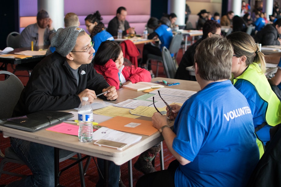 caption: Volunteers help with citizenship forms at a public workshop the City of Seattle hosted last January.