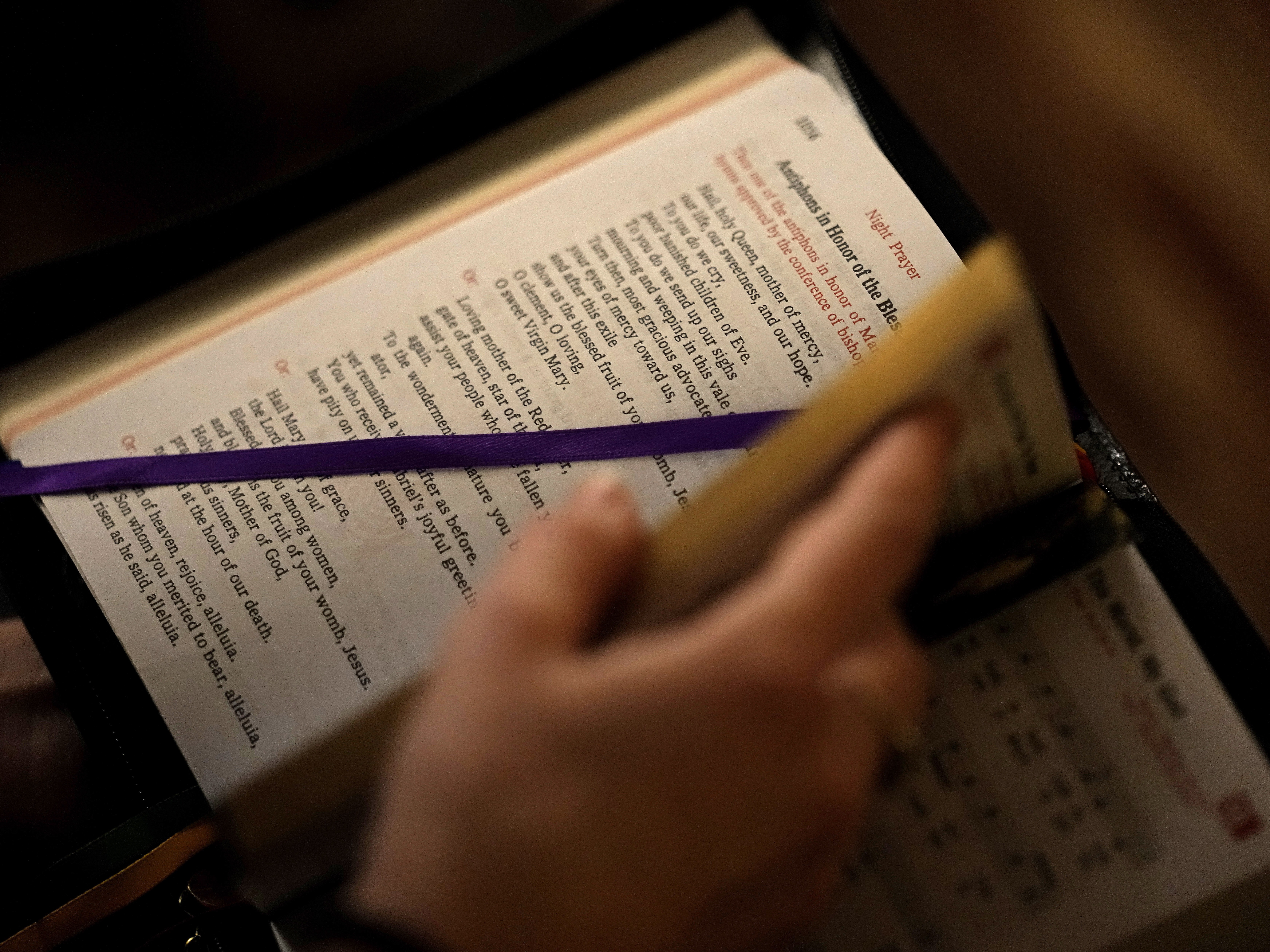caption: A college student looks through her prayer book. A new study found a decline in Christianity in the U.S.  (AP Photo/Charlie Riedel)