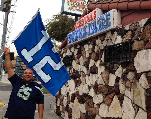caption: Cedric James Morris, founder of the Los Angeles Seahawks fan group, stands outside Backstage, in Culver City. The bar has become so overrun with Seahawks fans on Sundays that Morris has a list of overflow bars he hands out to fans when Backstage fills up.