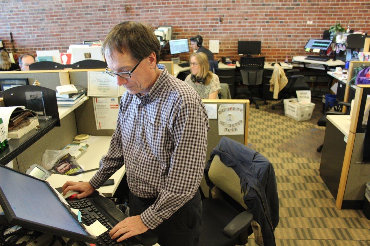 caption: Inspired by his interview, KUOW's Ross Reynolds chooses to stand at his desk when not in the studio.