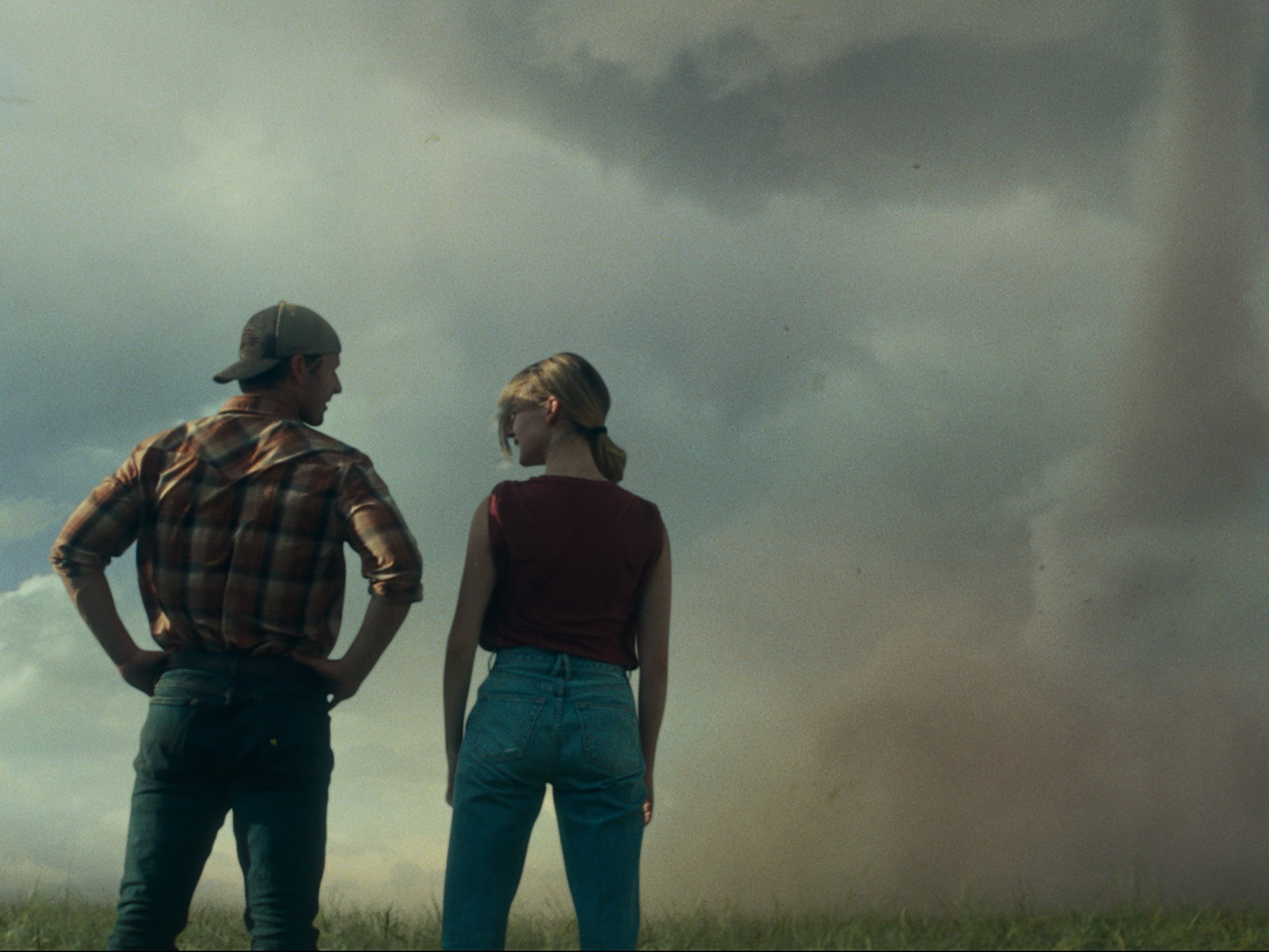 caption:  Glen Powell and Daisy Edgar-Jones play rival storm chasers in <em>Twisters</em>.