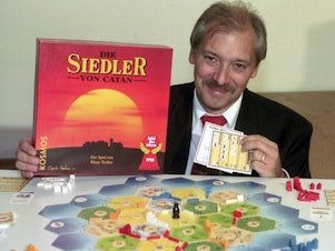 caption: Klaus Teuber, a dental technician from Darmstadt, presents his game The Settlers of Catan on Sept. 29, 1995, in Frankfurt, Germany.