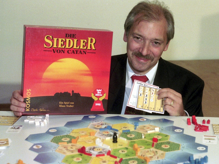 caption: Klaus Teuber, a dental technician from Darmstadt, presents his game The Settlers of Catan on Sept. 29, 1995, in Frankfurt, Germany.