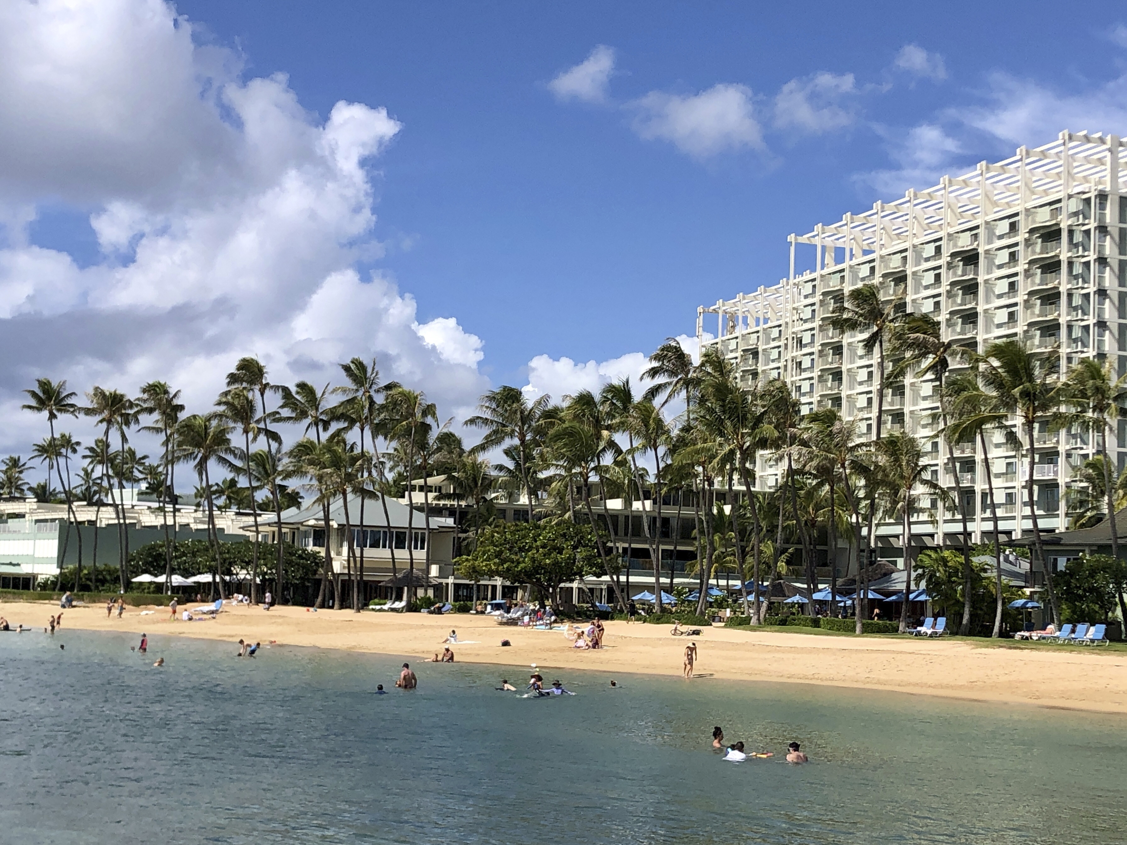 caption: People are seen on the beach and in the water in front of the Kahala Hotel &amp; Resort in Honolulu, Nov. 15, 2020.