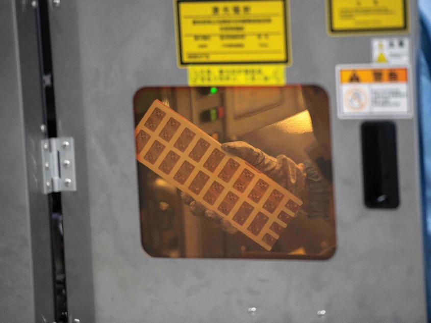 caption: A worker is seen inside the production chain at Renesas Electronics, a semiconductor manufacturer, in Beijing on May 14, 2020. A global computer chip shortage is affecting automakers.